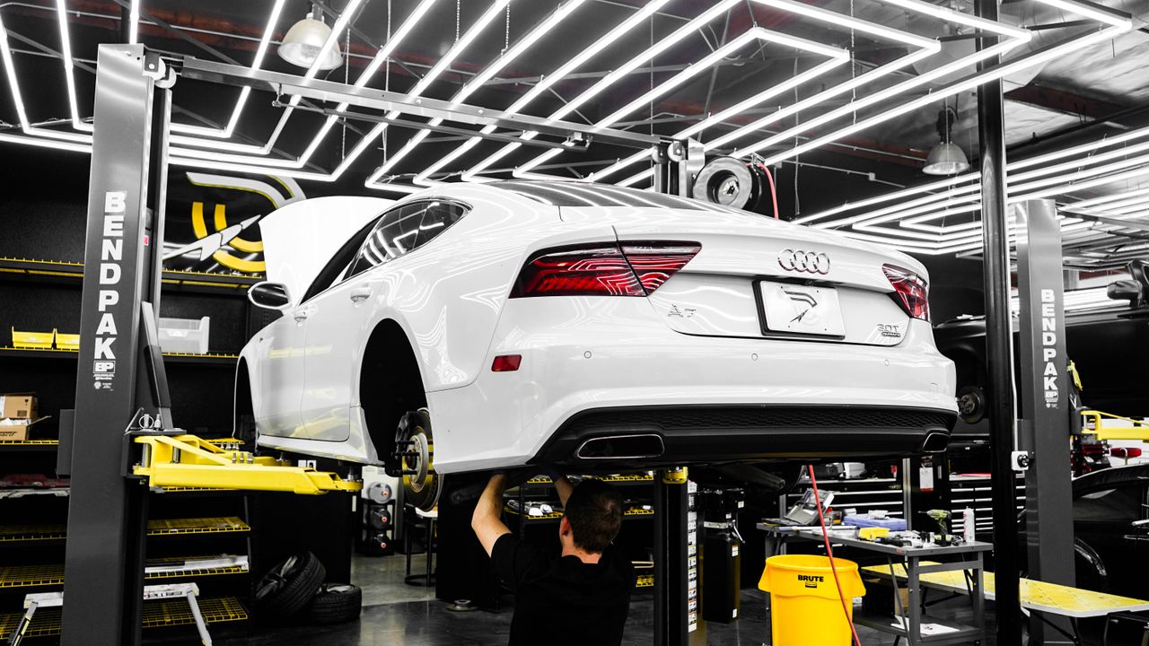 Mastering the First Impression: Your intriguing post title goes here White luxury car being serviced by mechanic in a modern garage setting.